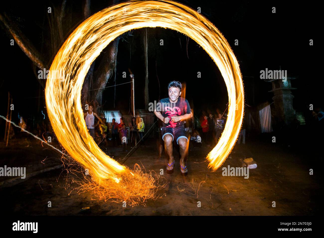 In this photo made with slow shutter speed, an Indonesian youth jumps ...