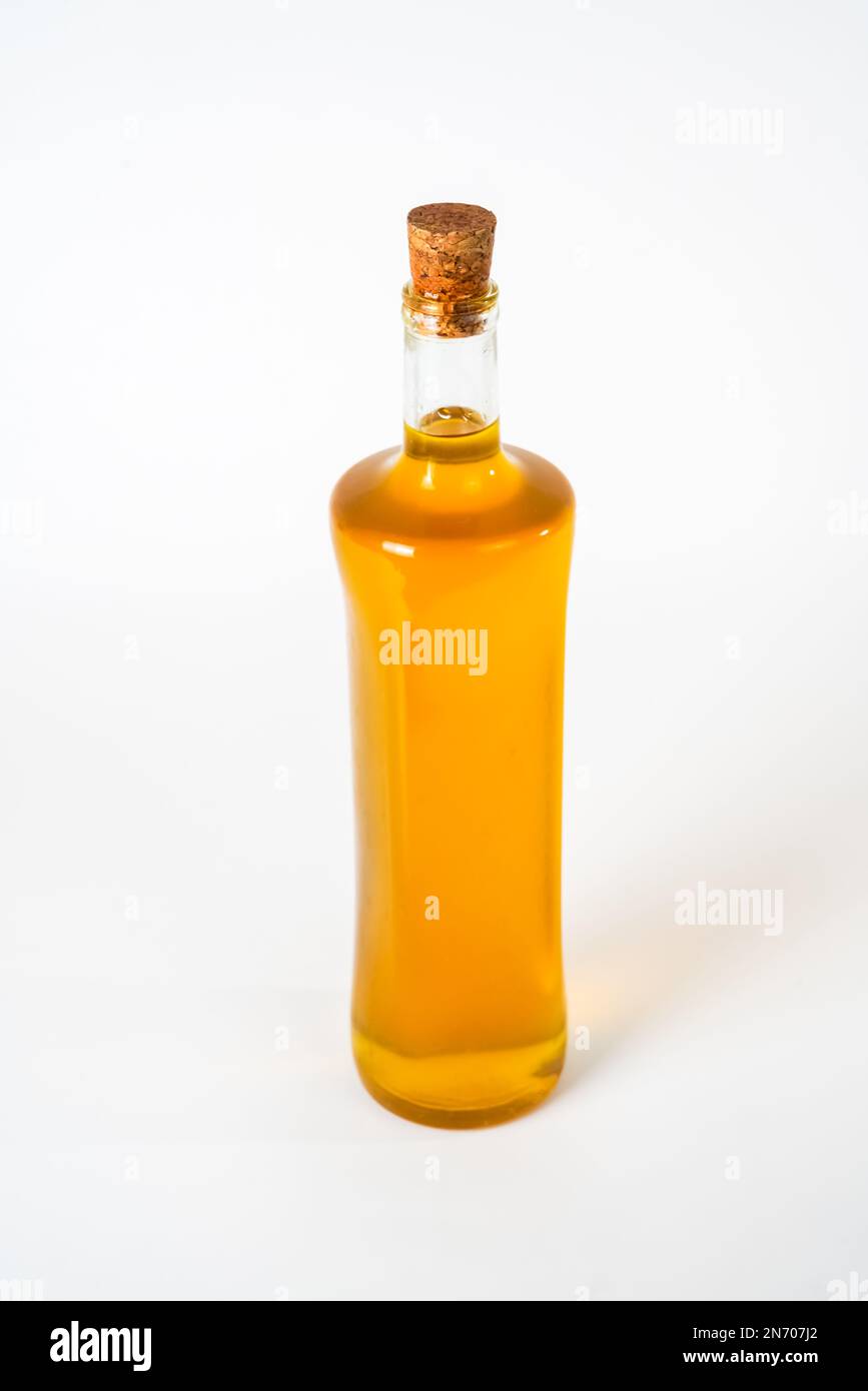 Olive oil in a glass bottle with a cork stopper isolated on white
