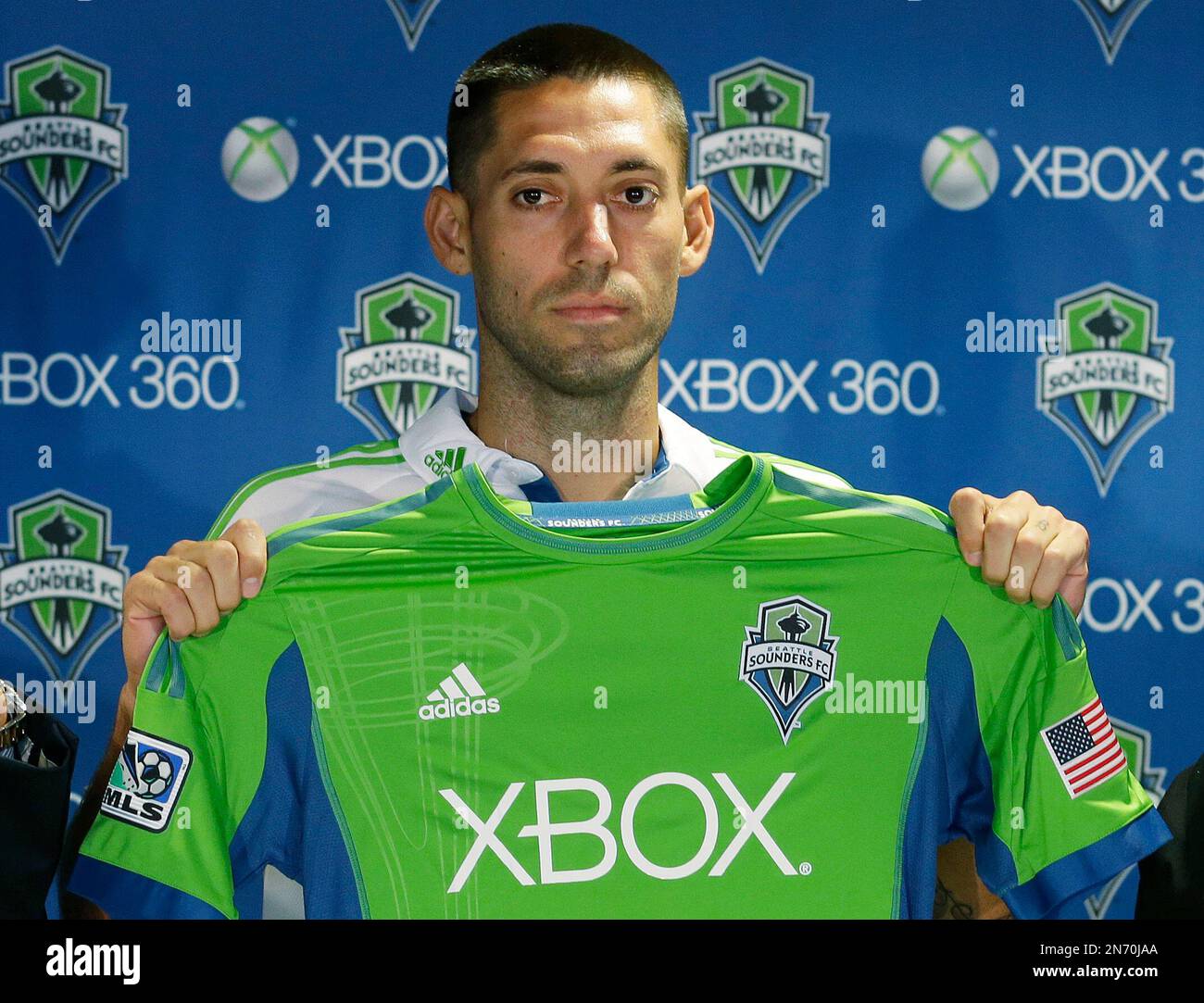 Clint Dempsey holds up a Seattle Sounders jersey after he was introduced as the newest player for the MLS soccer team Monday Aug. 5 2013 in Seattle. Dempsey previously played for Tottenham
