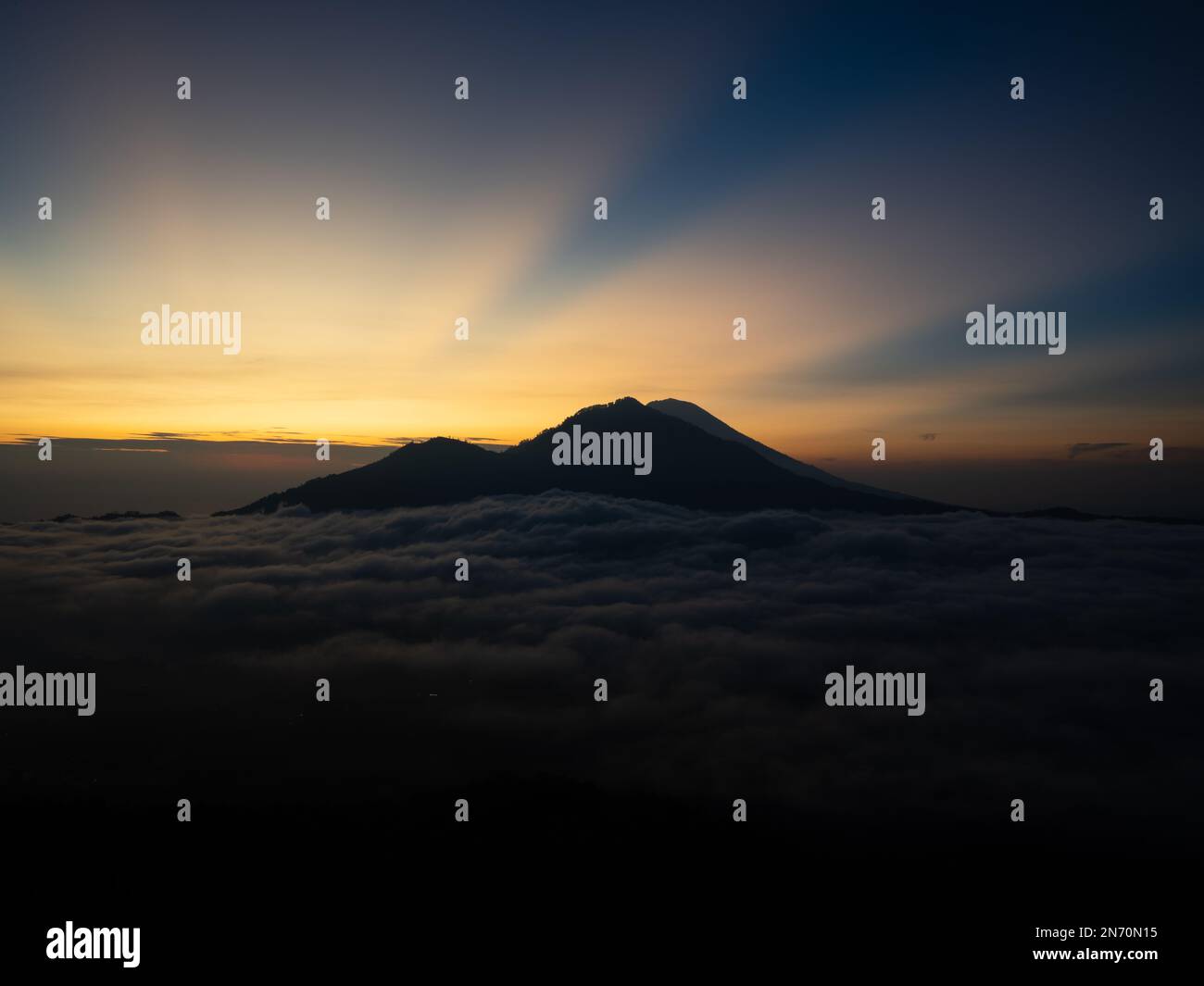 A scenic sunrise above clouds with a mountain volcano view in Bali ...