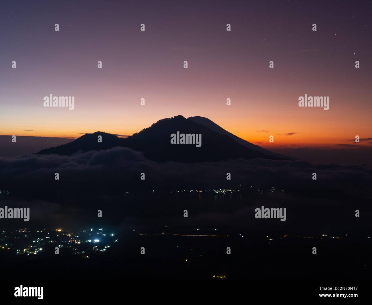 A scenic sunrise above clouds with a mountain volcano view in Bali ...