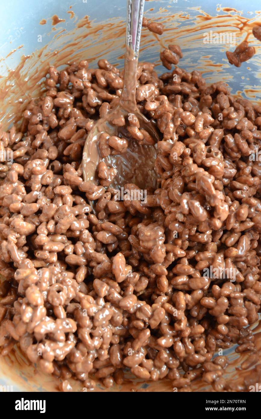 Chocolate Rice Krispie Cake Making - Home Baking - Rice Krispies In Mixing Bowl  With Spoon Stock Photo
