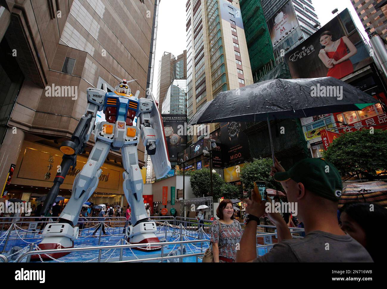 A man takes photos of a 1/3 scale model of the giant robot Gundam, made