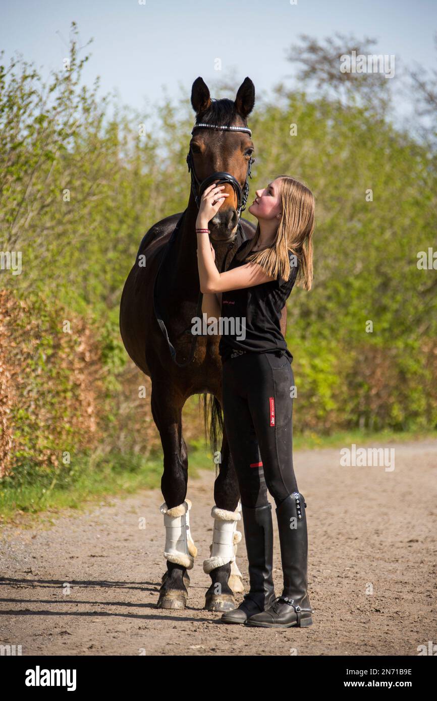 Teenage girl cuddling with her brown horse Stock Photo