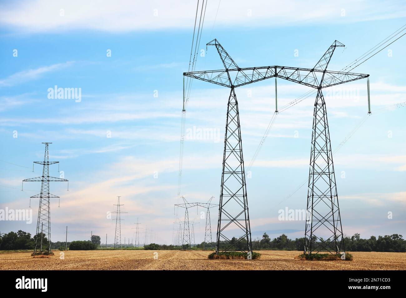 High voltage towers with electricity transmission power lines in field ...