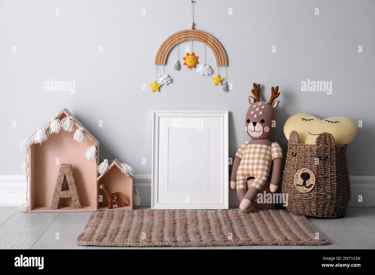 Empty photo frame and cute toys near wall in baby room. Interior design ...