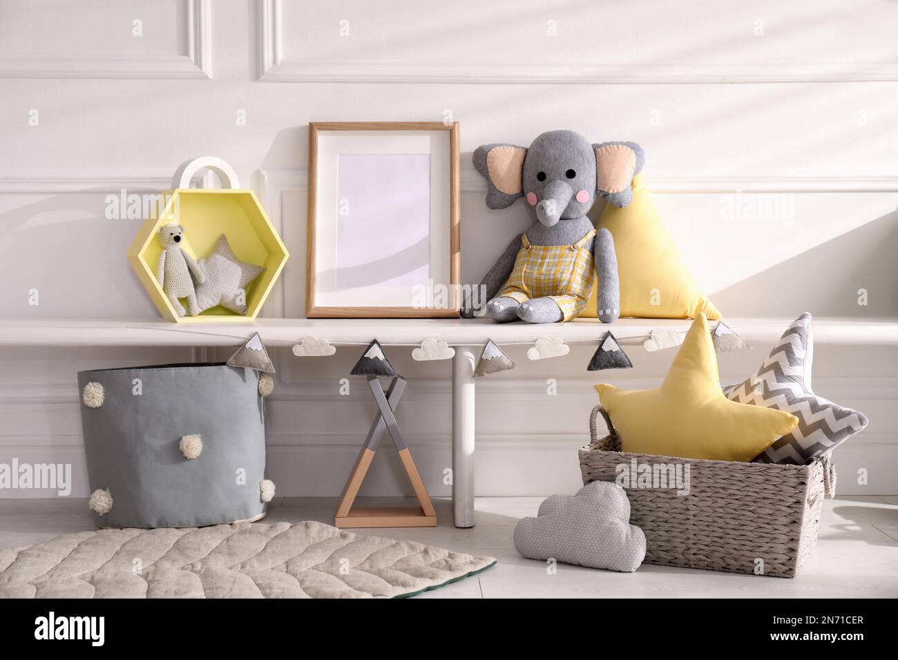 Empty photo frame and cute toys near wall in baby room. Interior design ...