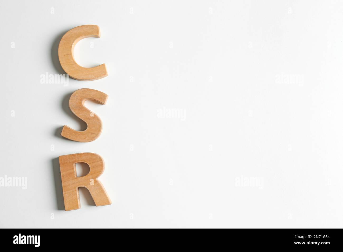 Wooden letters CSR on white background, top view. Corporate social ...