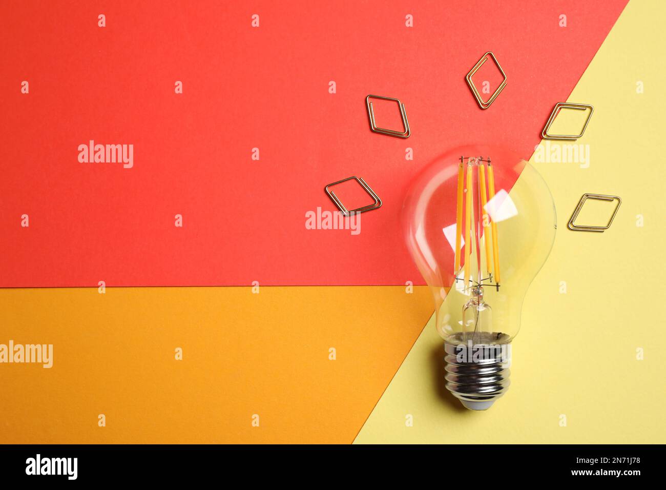 Flat lay composition with lightbulb on color background. Space for text Stock Photo