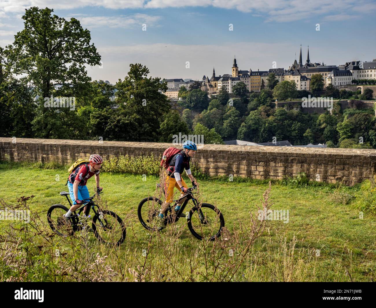E-mountain bikers on the grounds of Fort Thüngen, with a view of the old town of Luxembourg City Stock Photo