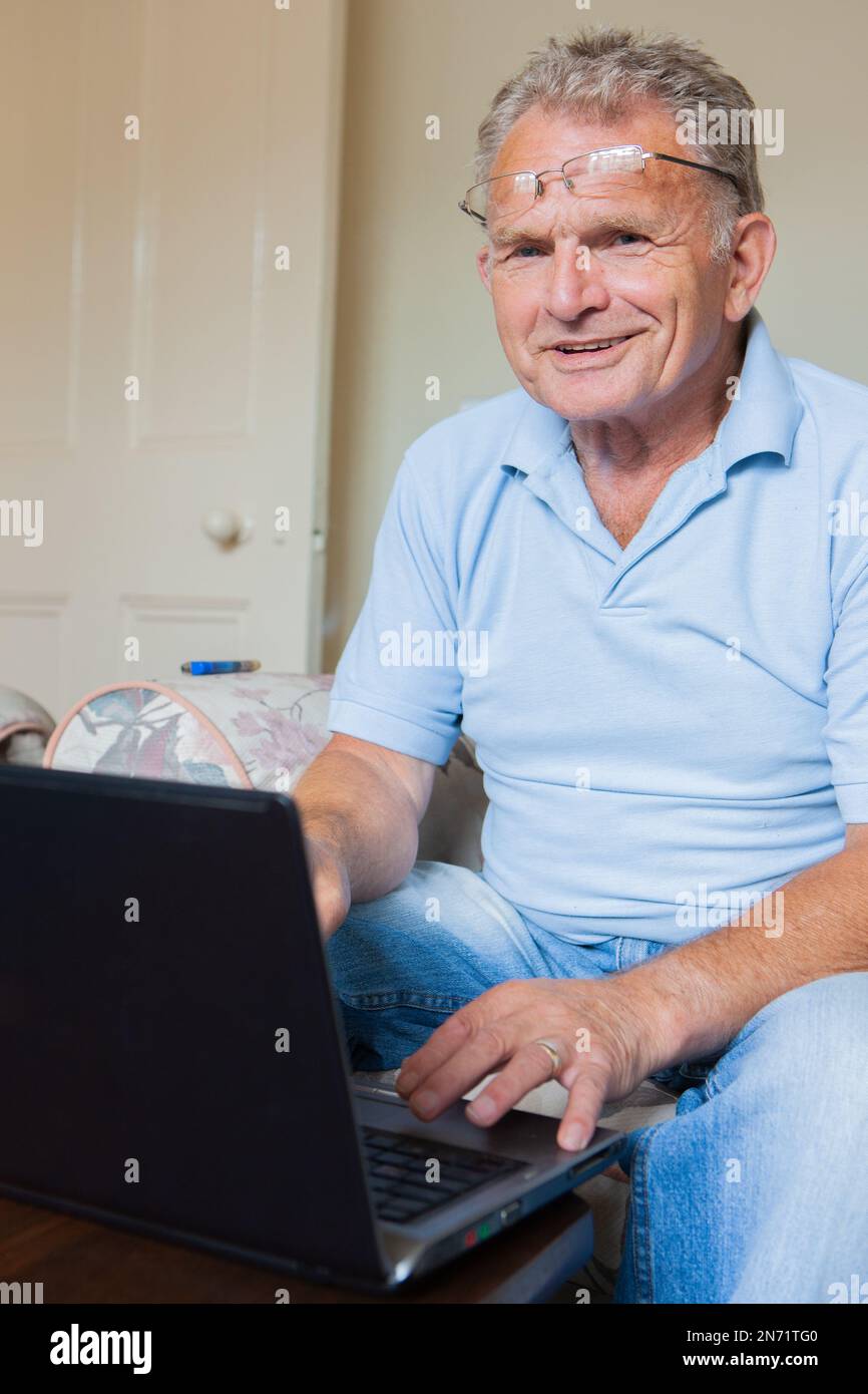 Retirement Silver Surfer. A senior man on his laptop computer at home. From a series of related