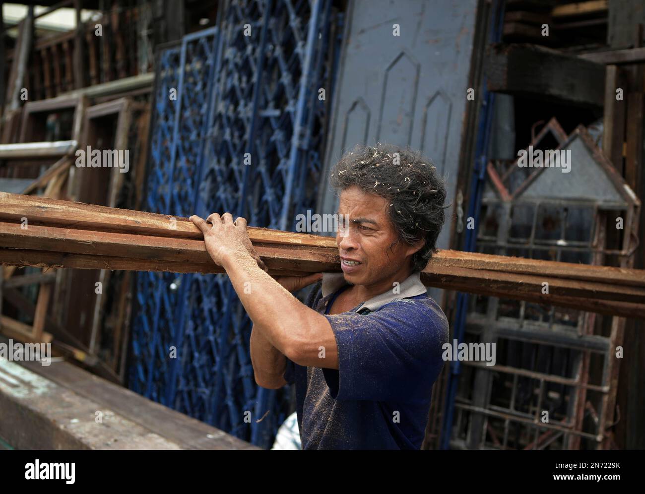 Filipino Pedro Casipit carries used wood which he had just cut at a