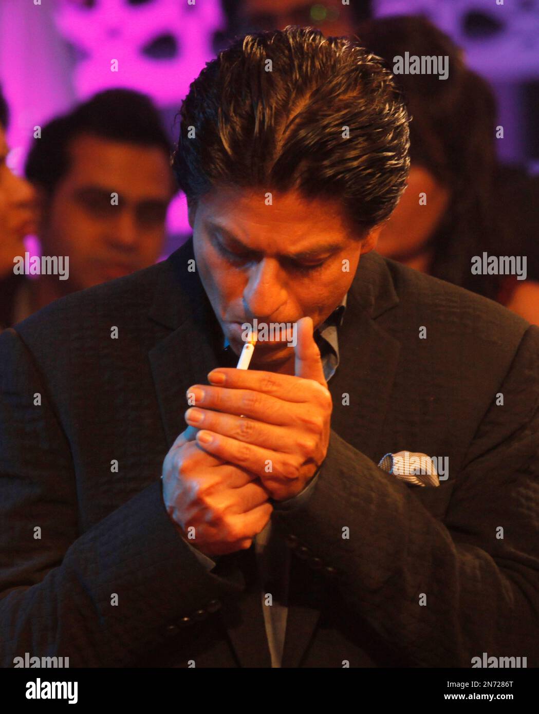Bollywood star Shah Rukh Khan lights a cigarette during an event to promote  his upcoming movie 