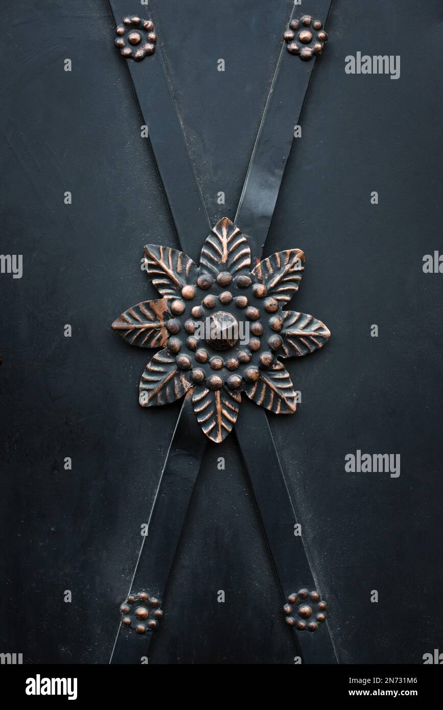 detail of flower ornament on old black iron door Stock Photo