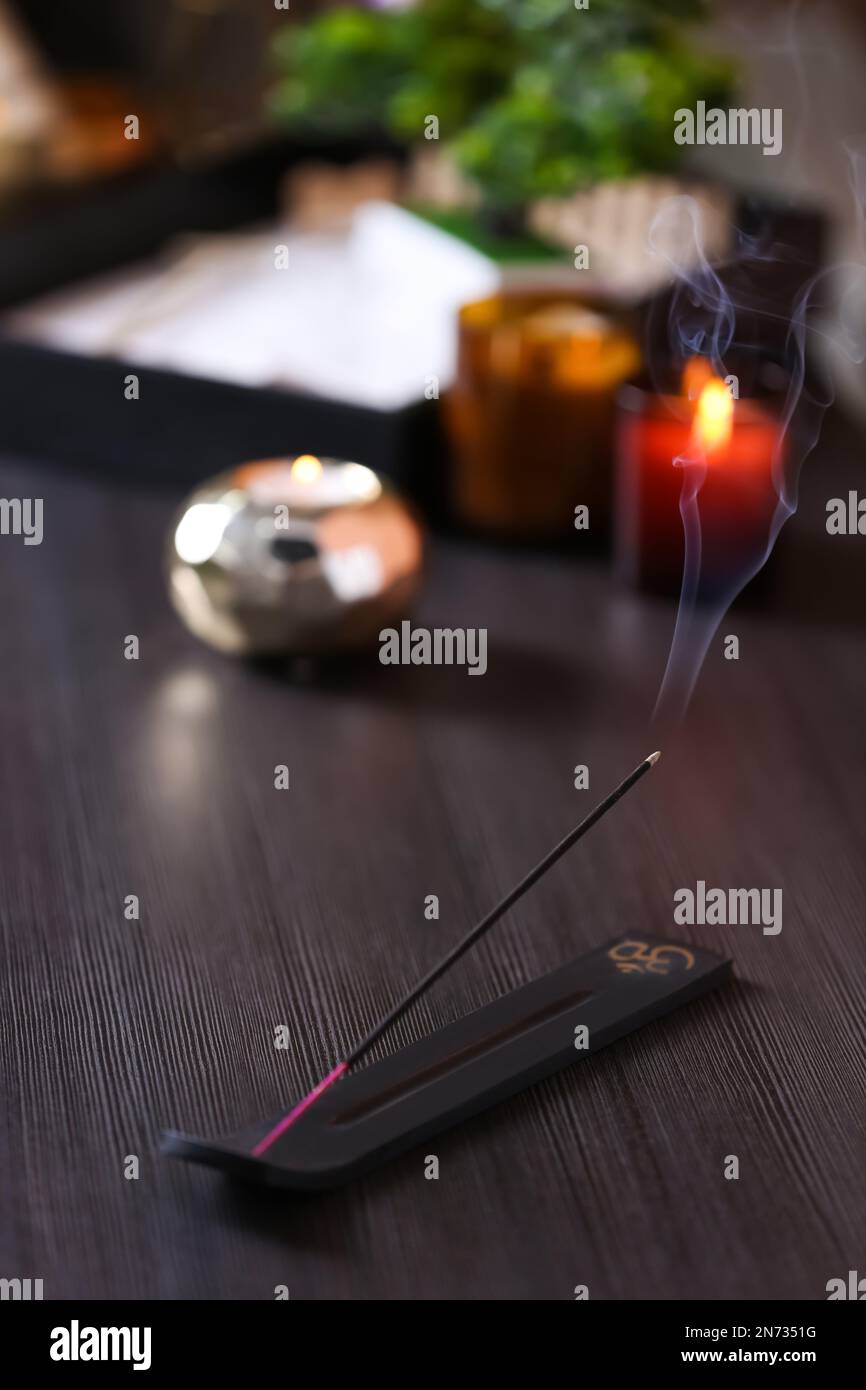 Incense stick smoldering on wooden table in room Stock Photo Alamy