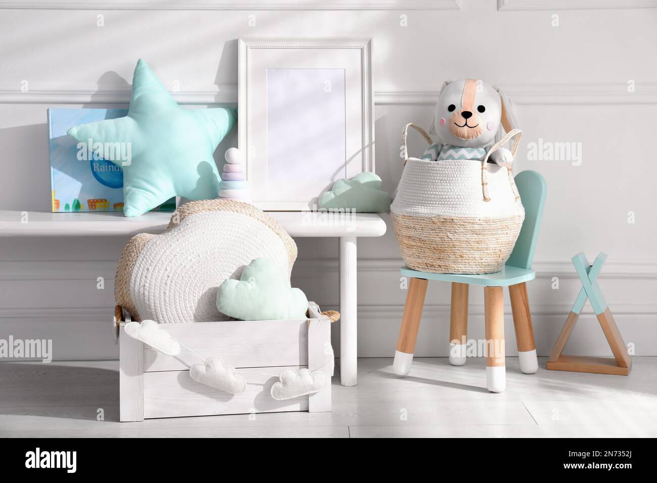 Empty photo frame and cute toys near wall in baby room. Interior design ...