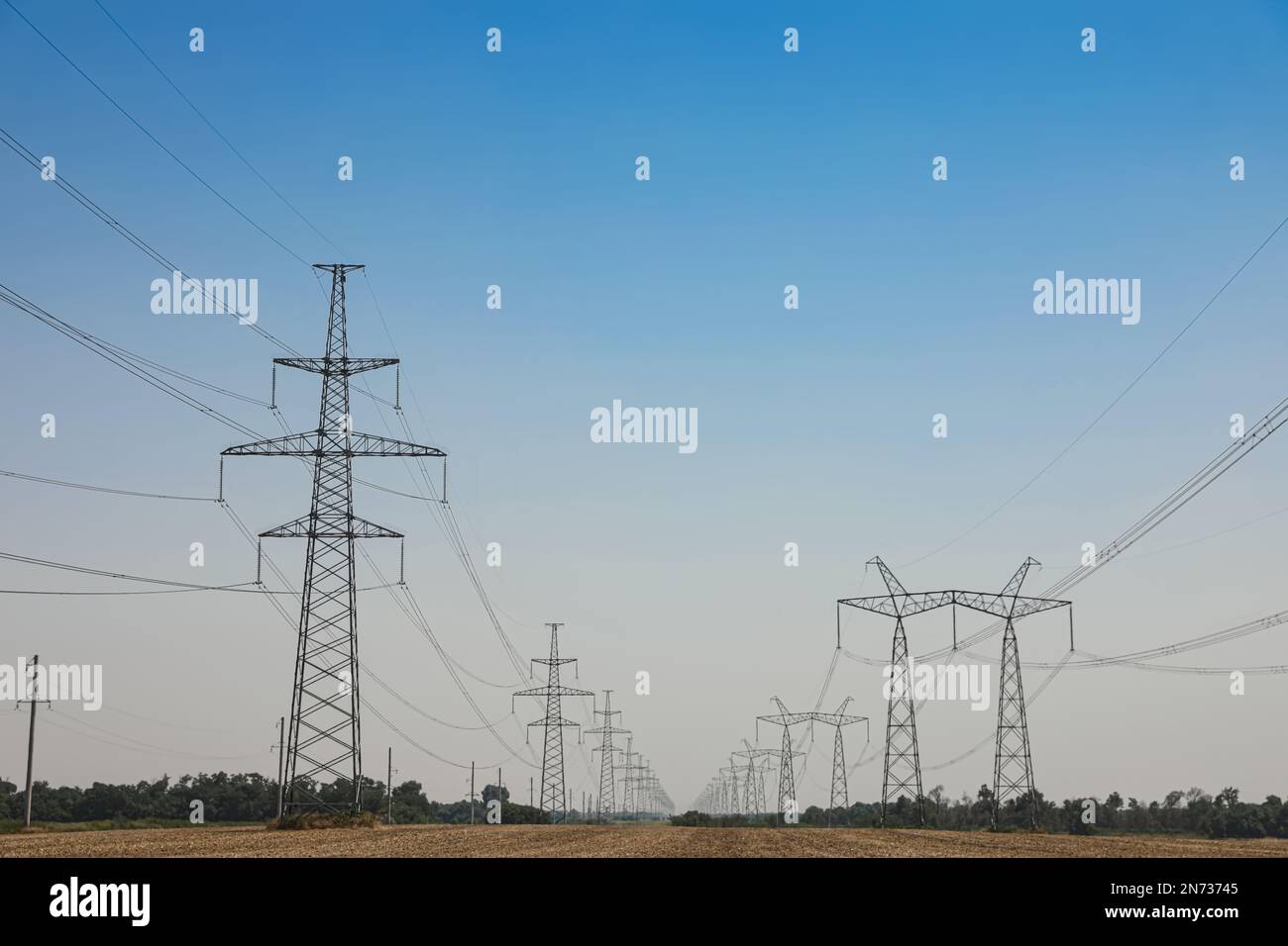 High voltage towers with electricity transmission power lines in field ...