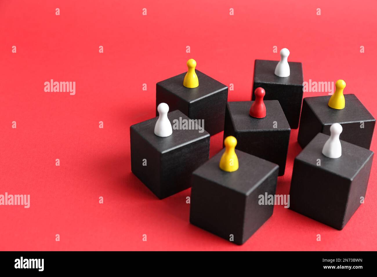Black blocks with playing pieces on red background, space for text. Roles and responsibility concept Stock Photo