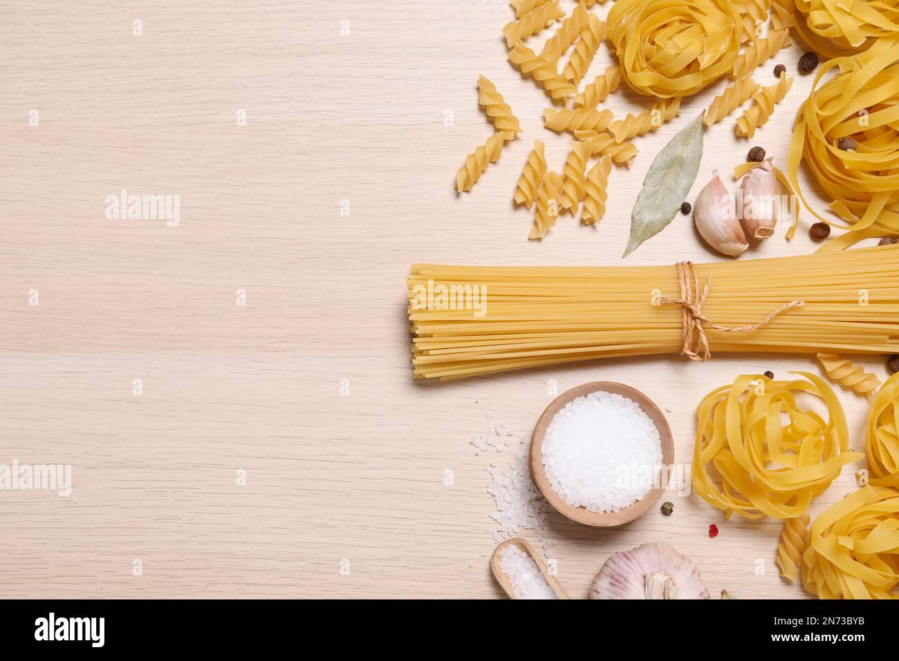 Flat lay composition with different types of pasta on light wooden ...