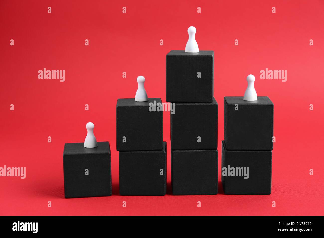 Black blocks with playing pieces on red background. Roles and responsibility concept Stock Photo