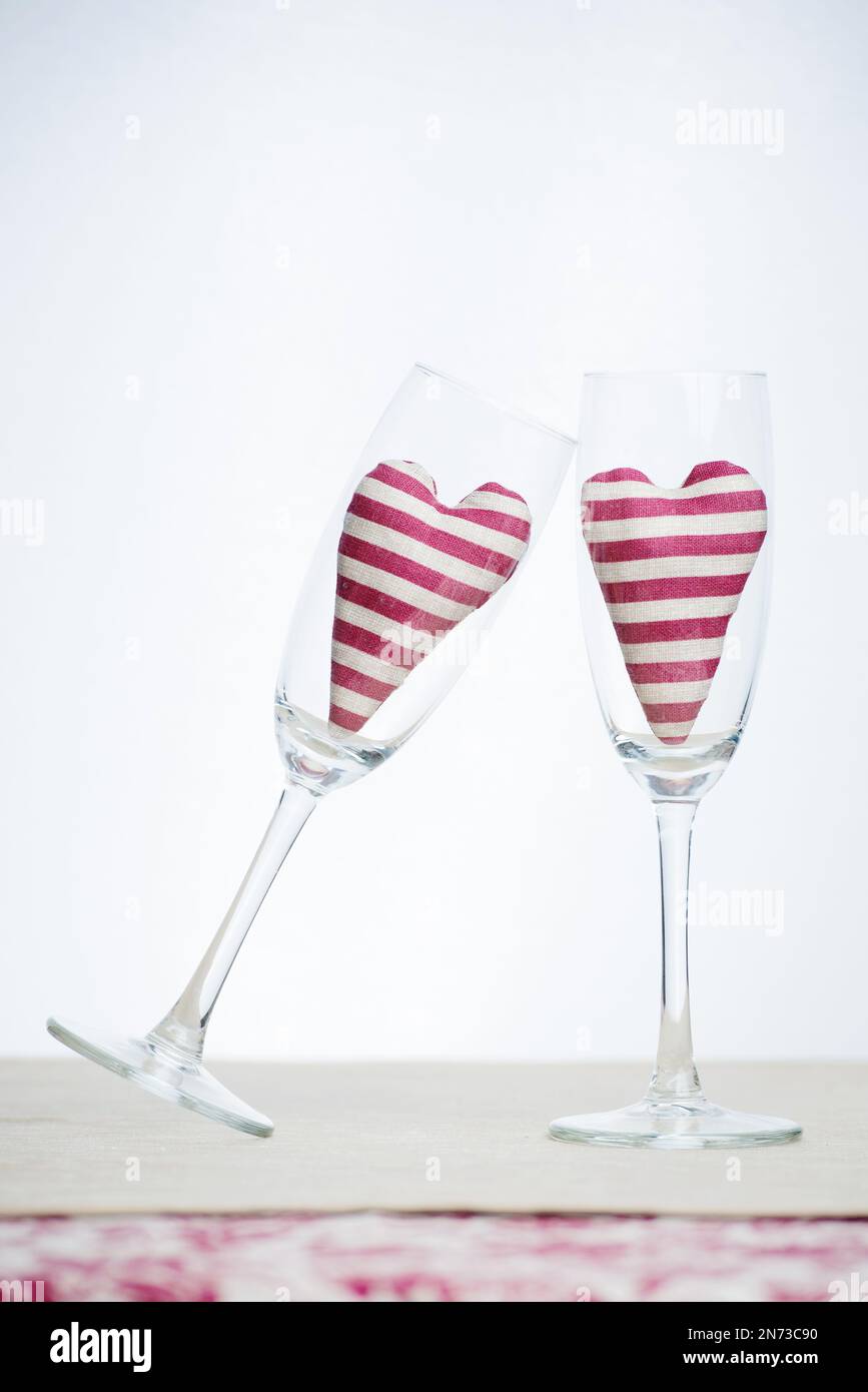 Valentine concept - two stripped hearts in champagne glasses Stock Photo