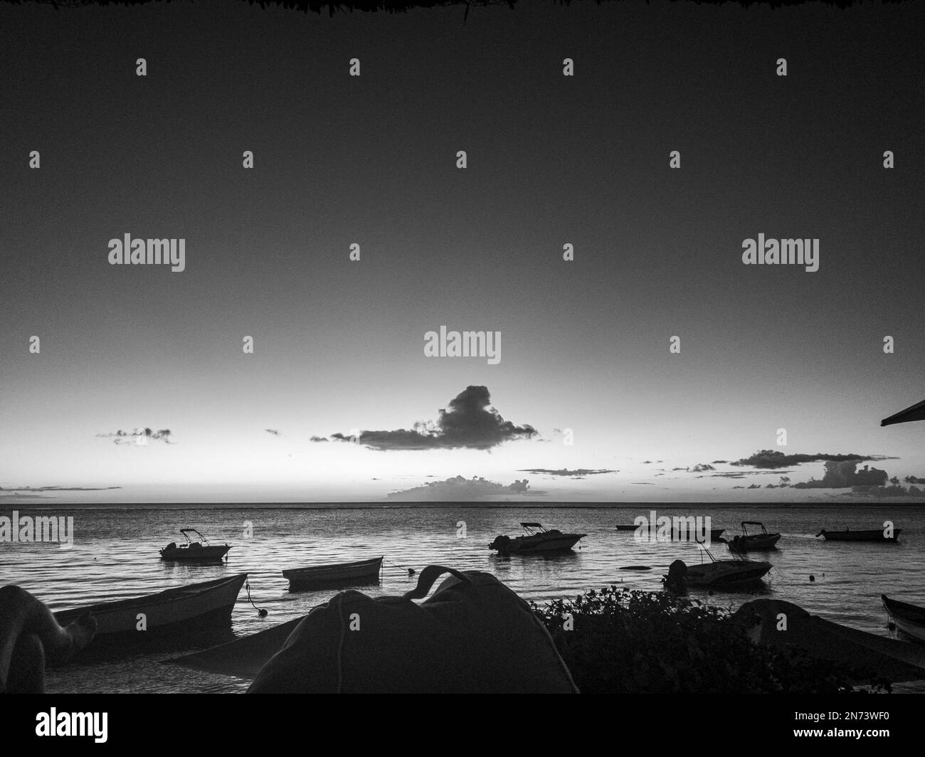 View on the ocean with boats and the horizon shortly after sunset. Mauritius Island, Africa Stock Photo