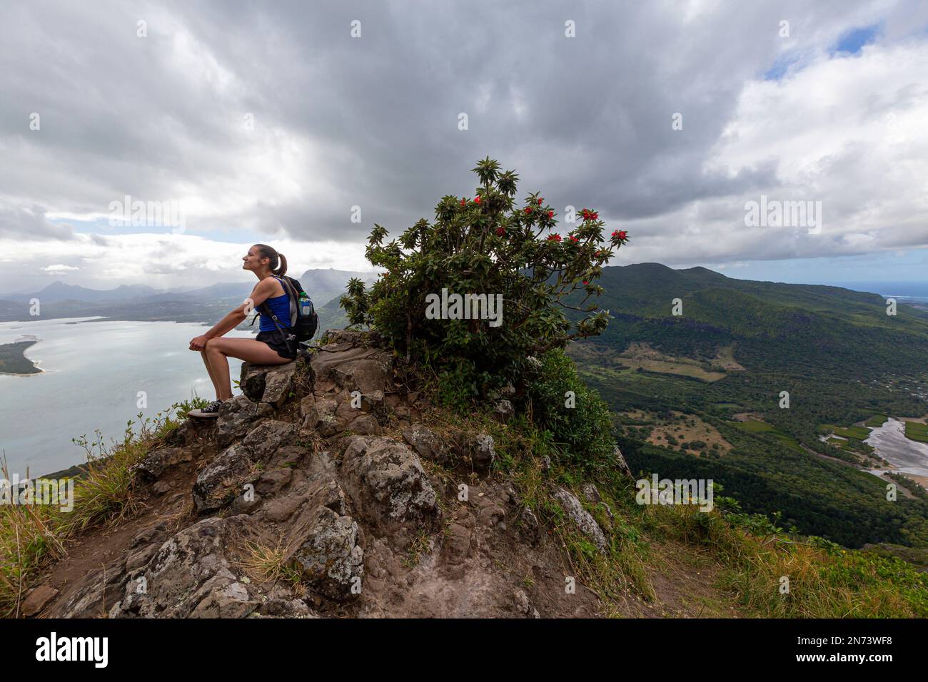 A young lady on top of Mauritius famous mountain Le Morne Brabant mountain. Stock Photo