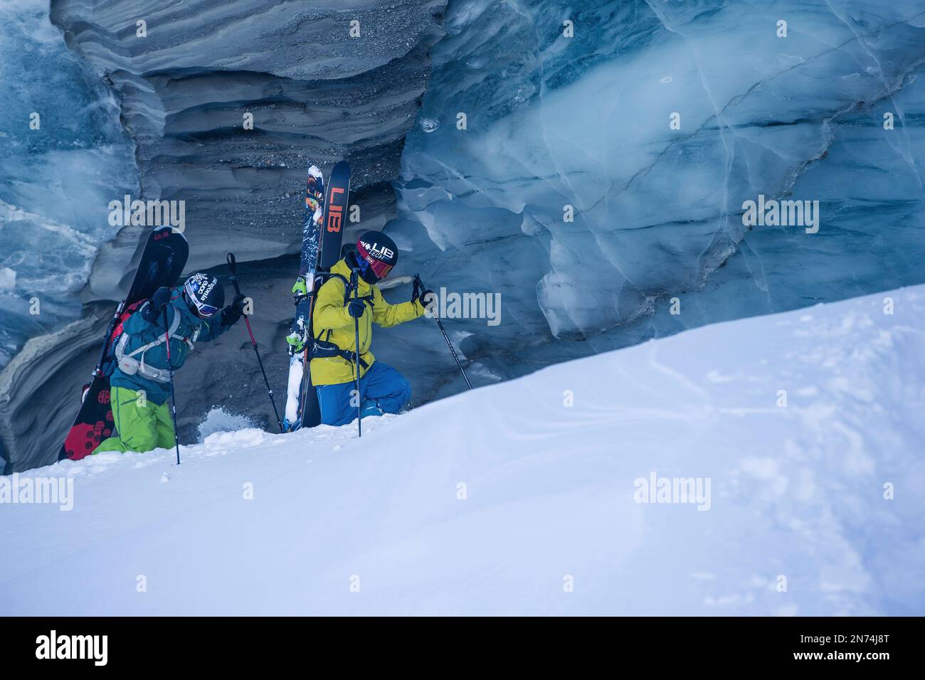 Two professional snowboarders and skiers explore and ski a crevasse / ice cave high up on the Pitztal glacier, Pitztal, Tyrol, Austria Stock Photo