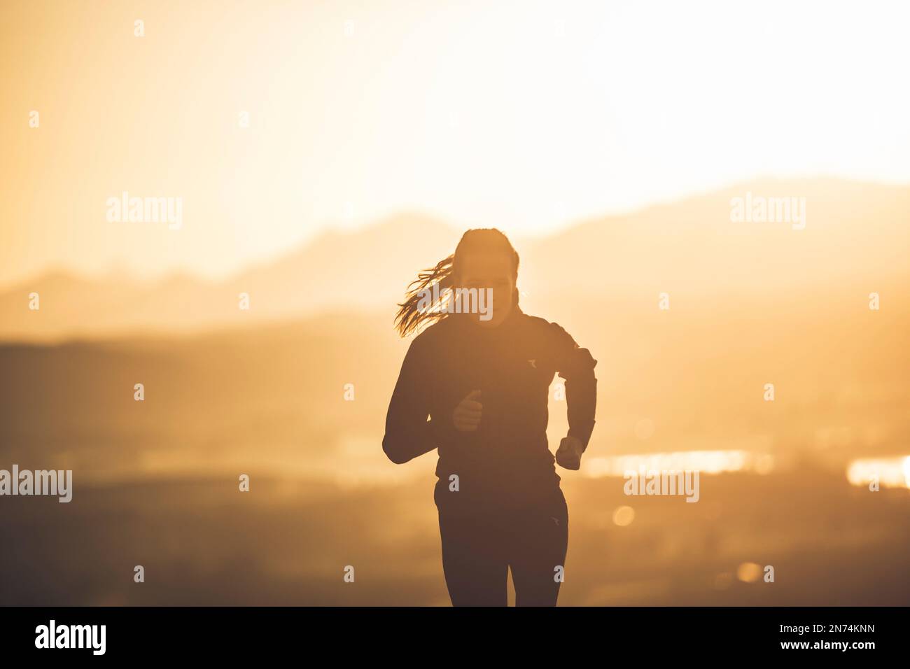 Professional triathlete running, morning atmosphere, sunrise, Auerberg, Allgäu, Bavaria, Germany Stock Photo