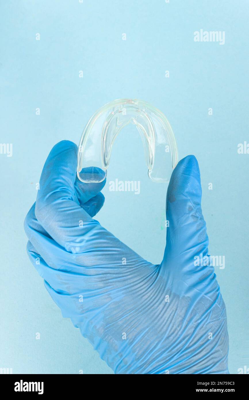 Tooth whitening, a tooth mold in doctors hand. Dental beauty treatment. Teeth retaining tools