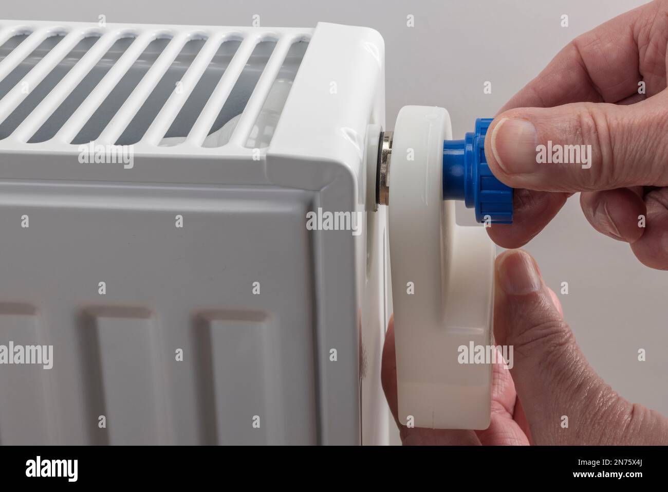 Man hand holding radiator air vent tank with integrated air vent key on