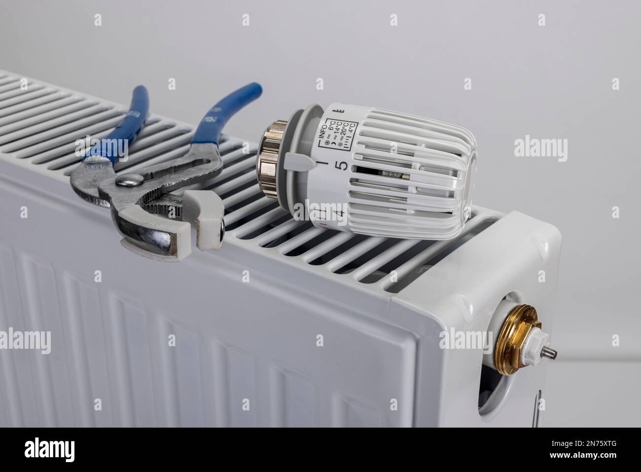 New heating thermostat lies on radiator hires stock photography and