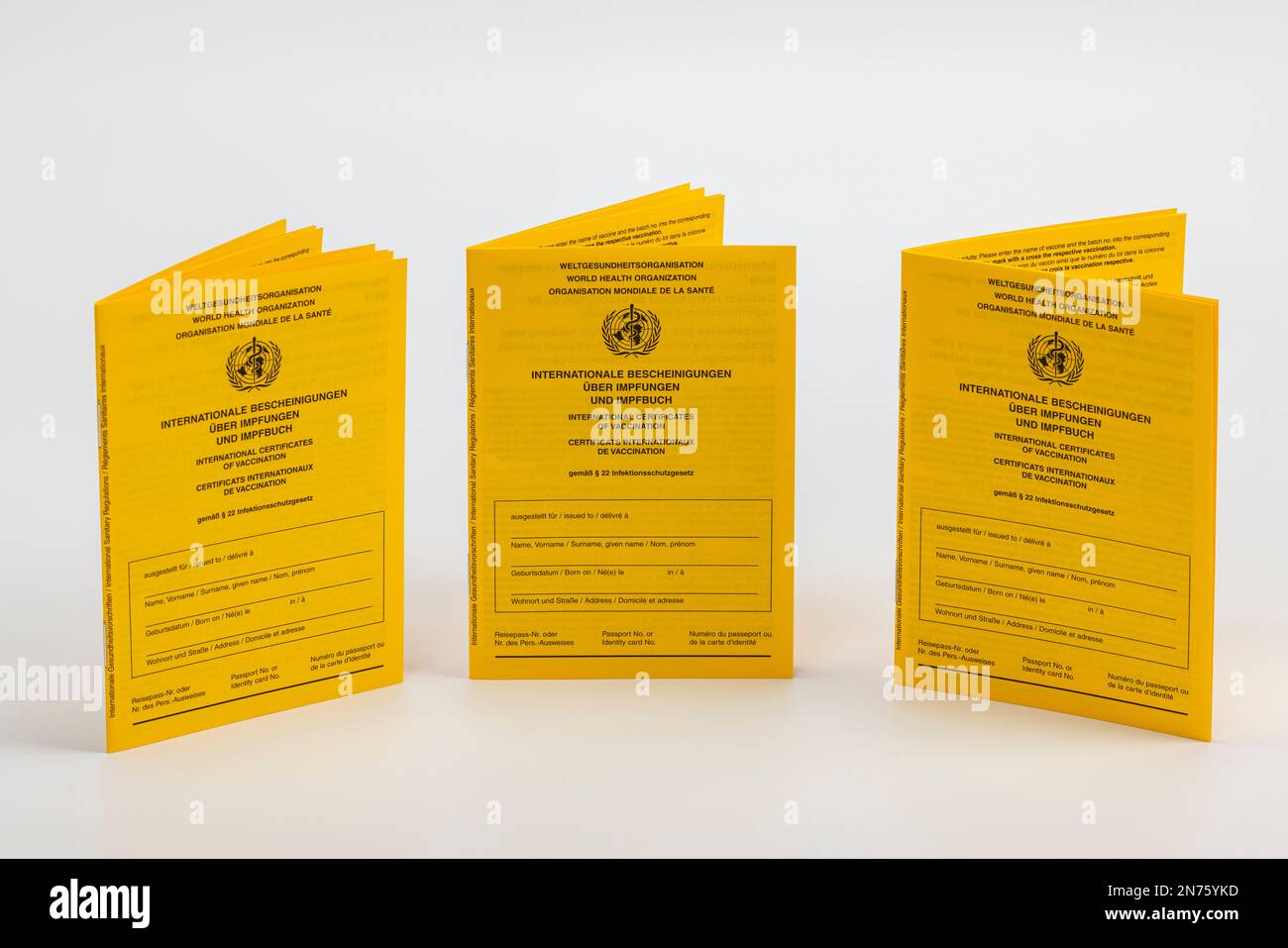 Three new international vaccination cards, yellow, white background, Stock Photo