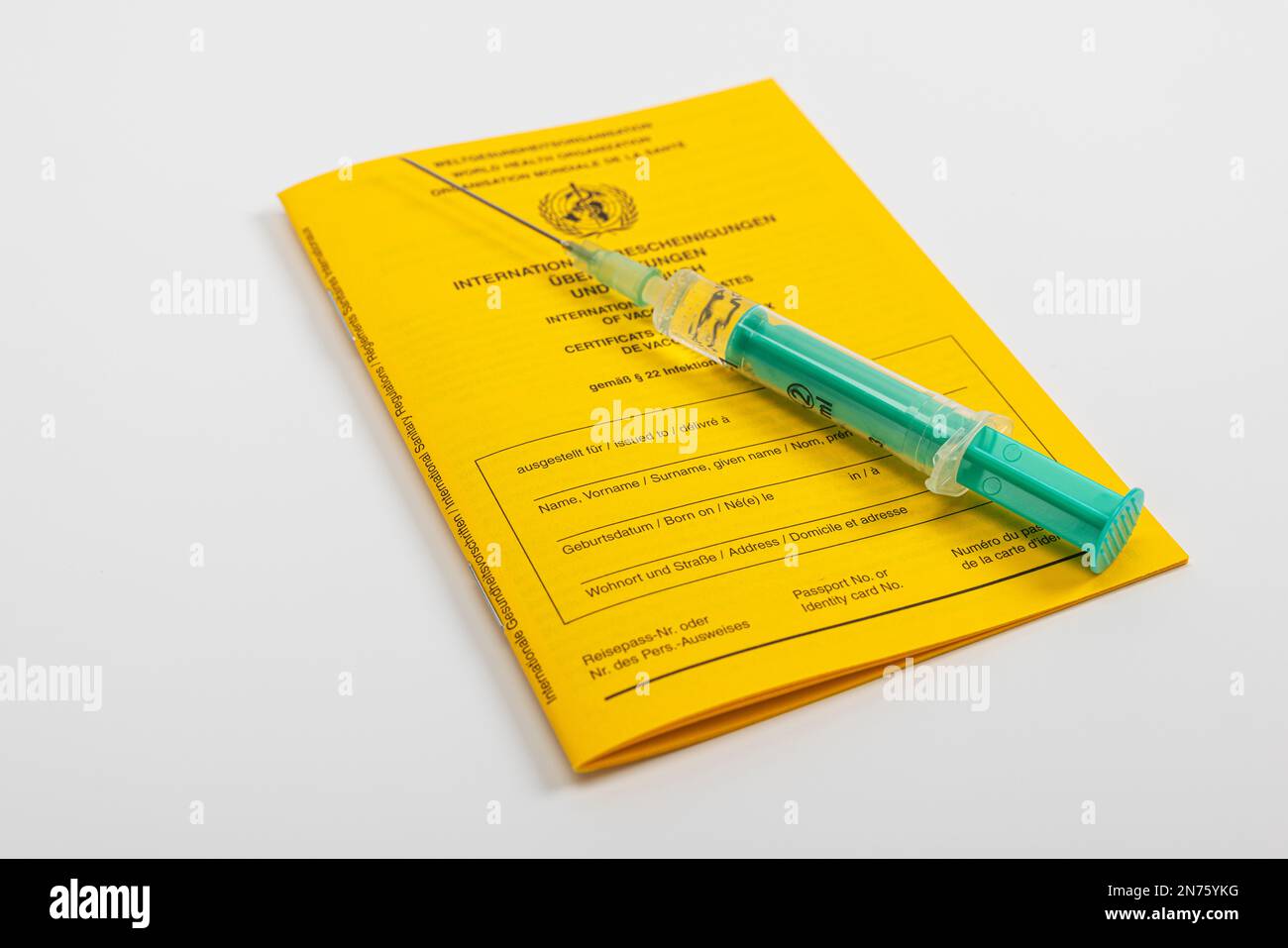 New vaccination card, international certificates of vaccinations, medical injection syringe, white background, Stock Photo
