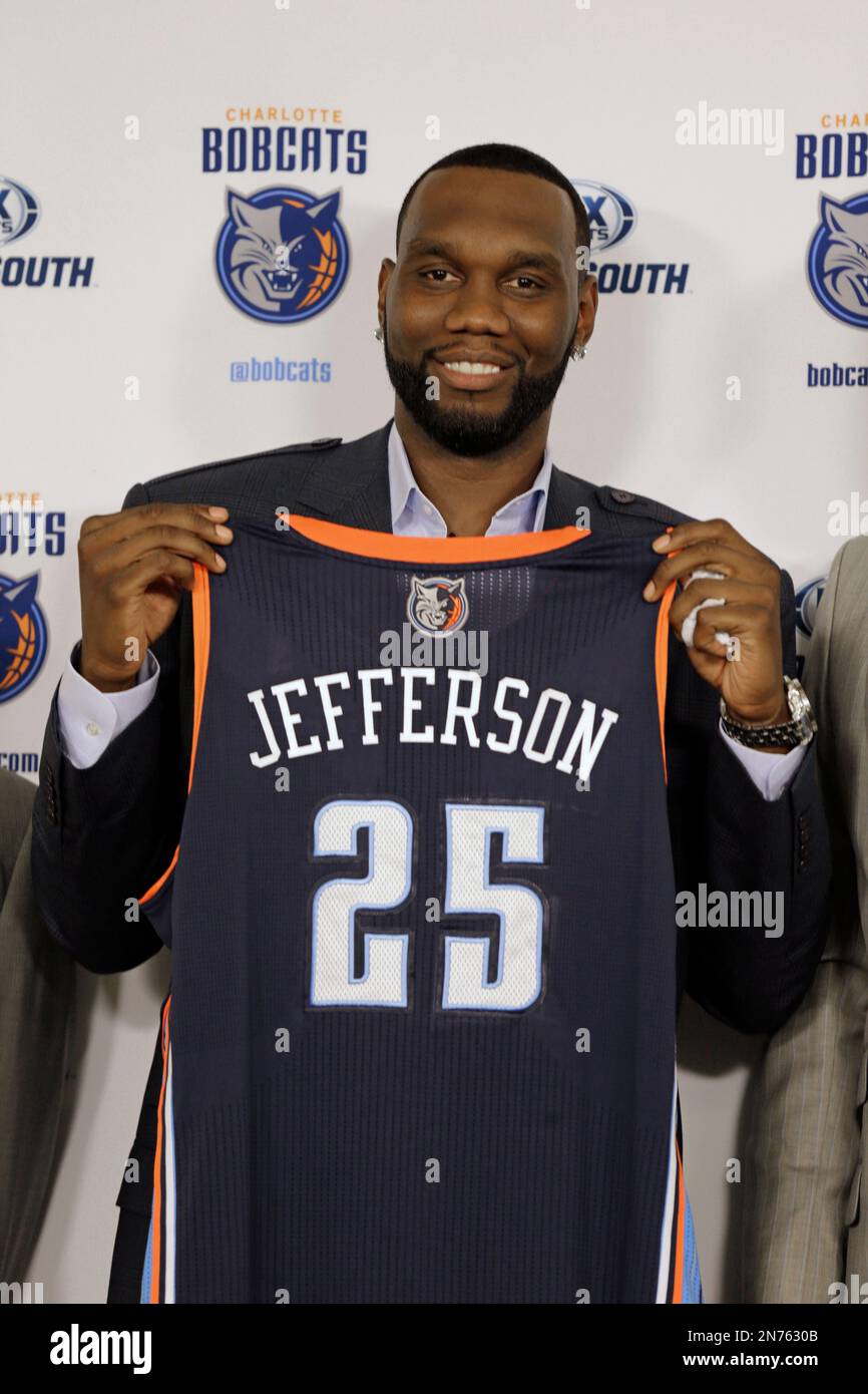 Charlotte Bobcats Al Jefferson poses with his jersey during a news conference for the NBA basketball team in Charlotte N.C. Wednesday July 10 2013. Jefferson a free agent signed with the Bobcats