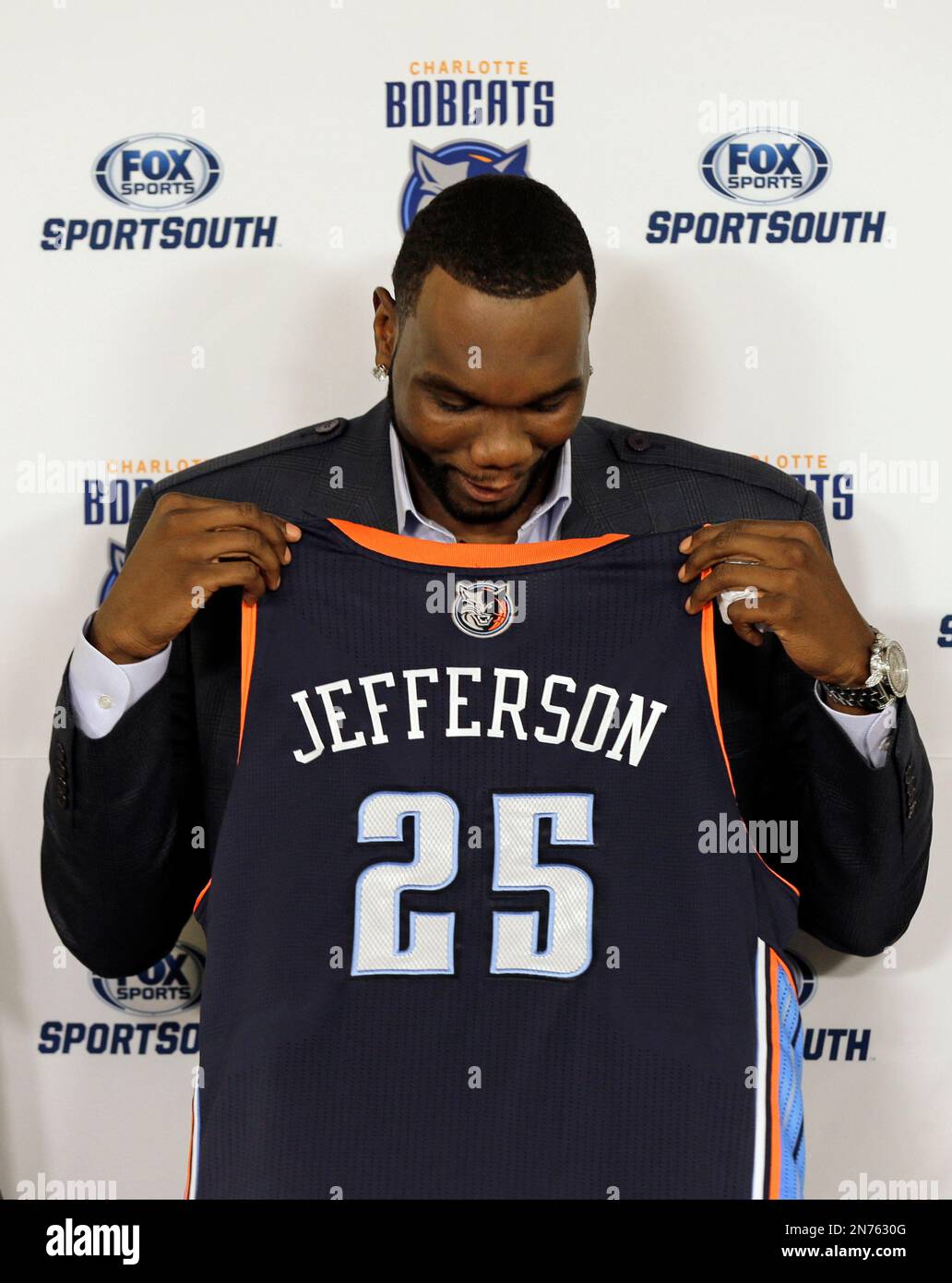 Charlotte Bobcats' Al Jefferson glances down at his jersey during a ...