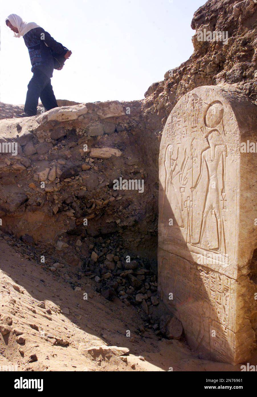 An Egyptian worker removes sand from the site were the tomb of an