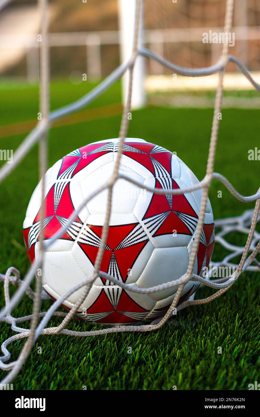 A vertical closeup of a soccer ball inside the goal net Stock Photo Alamy