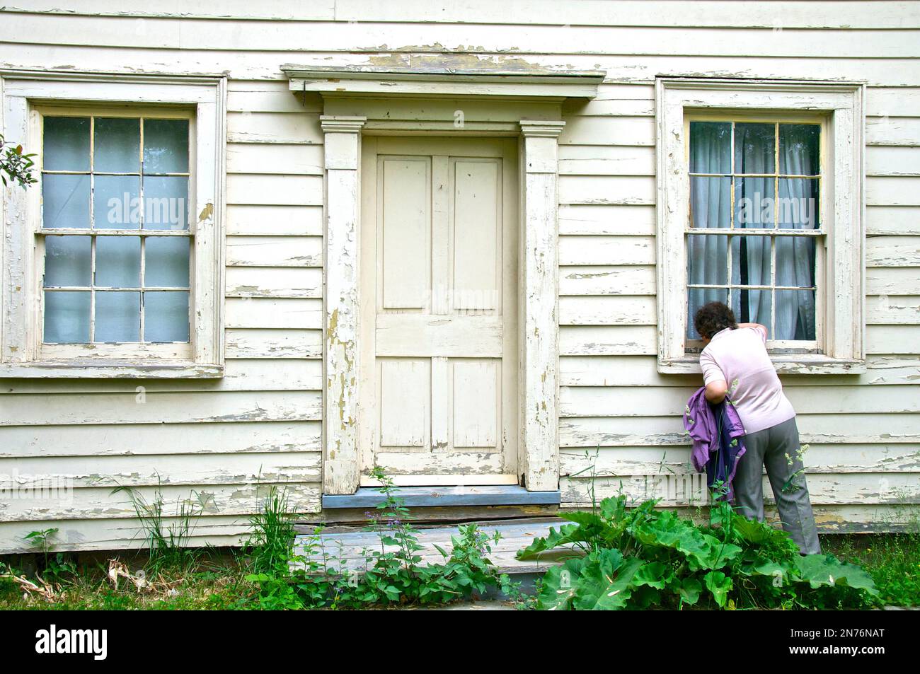 Women looking through the widow of a heritage home Stock Photo