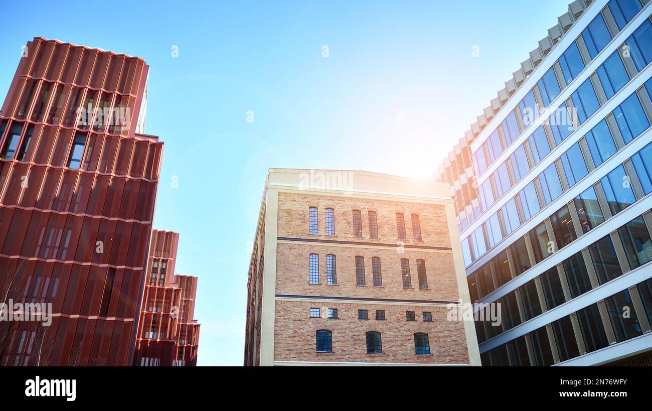 Revitalized red brick building and modern office building. Rising sun ...