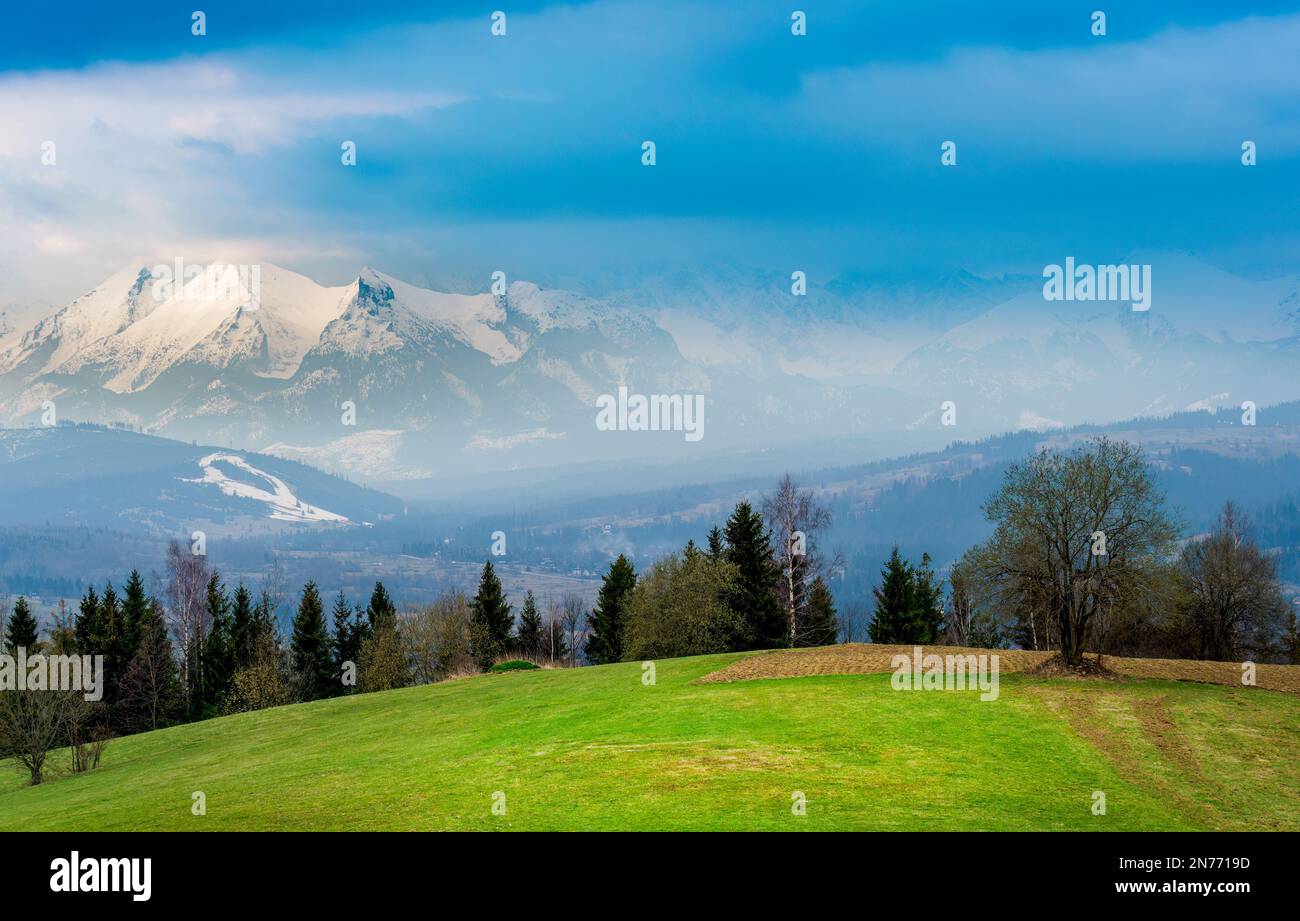 View of the Tatra Mountains from the viewpoint on Czarna Góra. It's spring in the valleys, and winter high in the mountains. Stock Photo