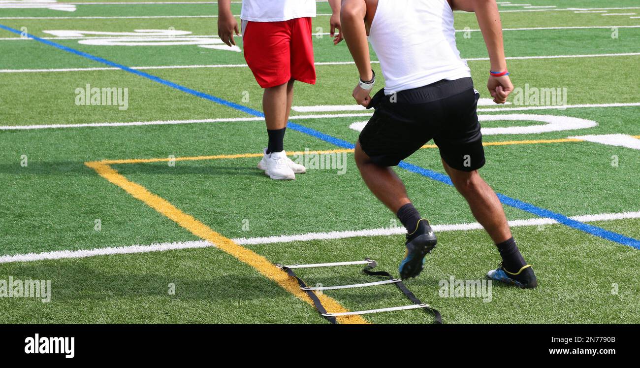 Rear view of one high school football player running the ladder drill