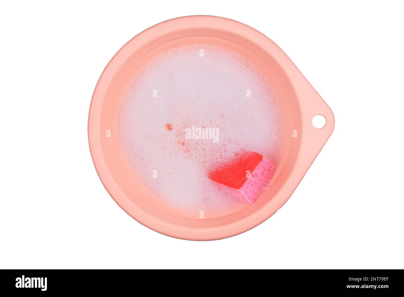Washing clothes in a pink basin. Detergent with washcloths. Top view. Isolate on a white background. Stock Photo