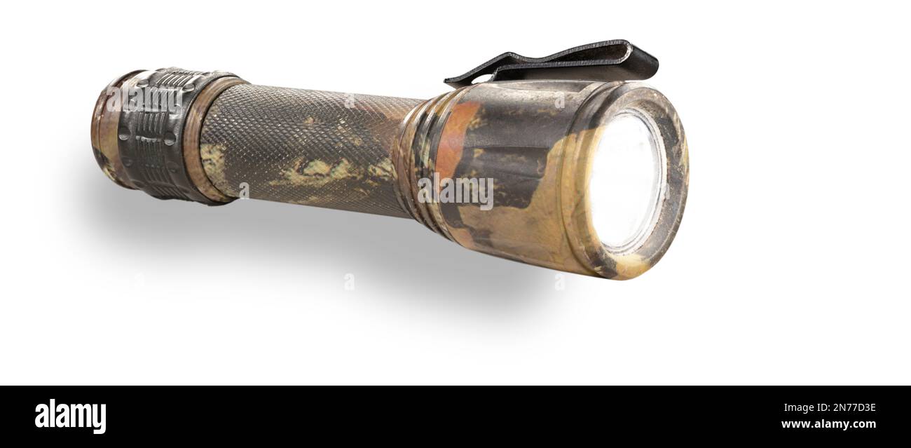 Waterproof pocket sized flashlight with camo pattern that is on with a shadow below Stock Photo