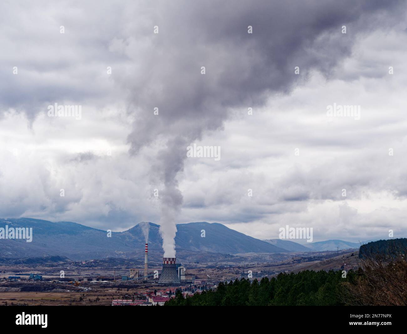Thermal power station expelling pollutants to the air. City with poor air quality due to thermal power plant. Burning fossil fuel. Toxic air. Stock Photo