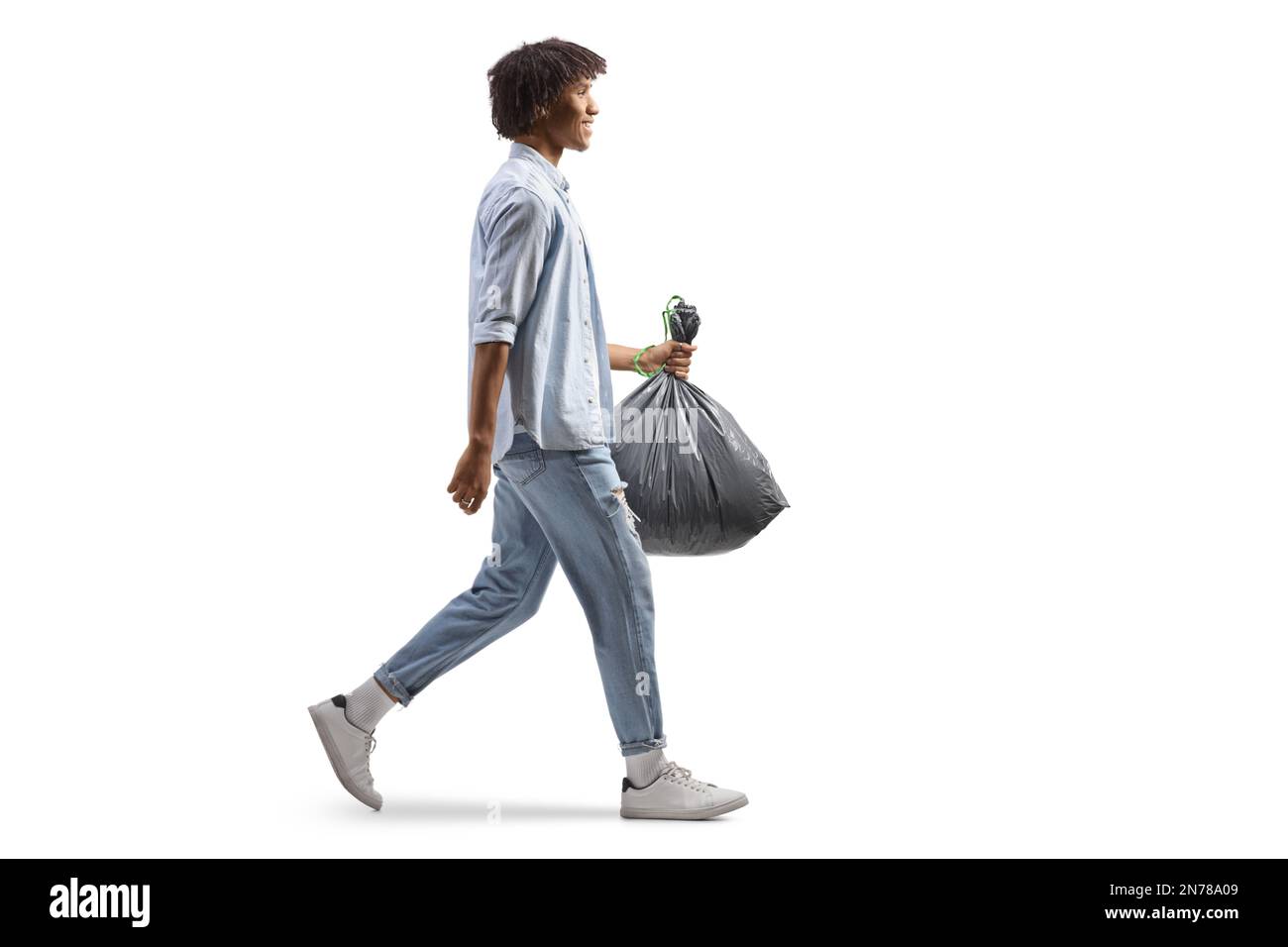 Man throwing out black eco-friendly recyclable trash bag in to big plastic  green garbage container. Stock Photo by nikolast1