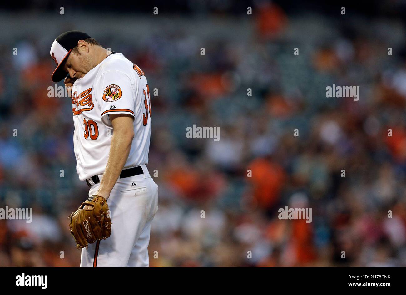 Baltimore Orioles starting pitcher Chris Tillman pauses to wipe sweat