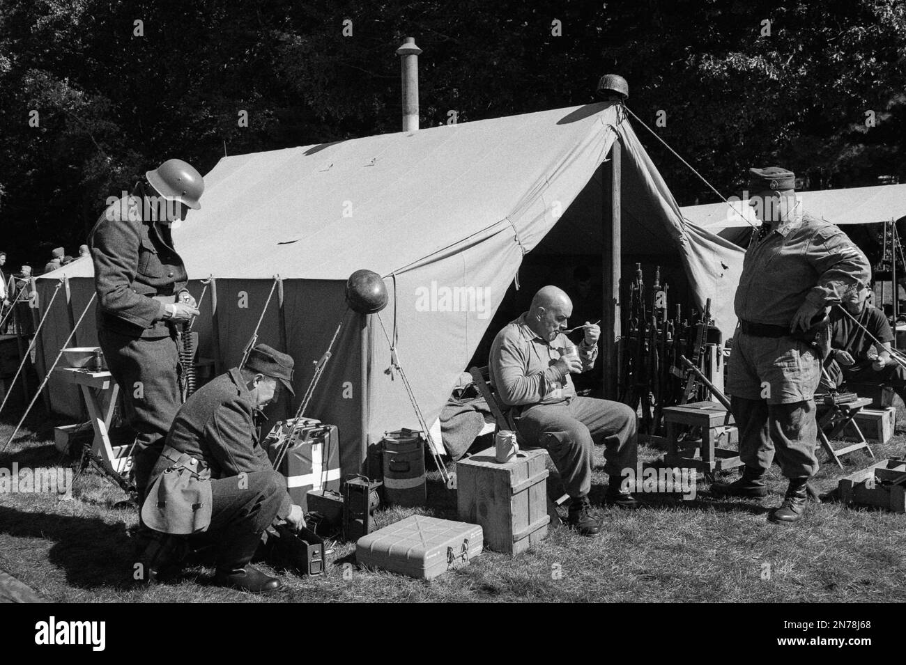 A WWII German camp with soldiers eating, working, and relaxing around a tent during a reenactment at the American Heritage Museum. The image was captu Stock Photo