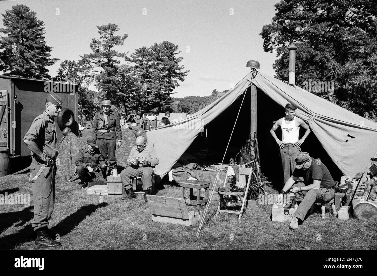 A WWII German camp with soldiers eating, working, and relaxing around a tent during a reenactment at the American Heritage Museum. The image was captu Stock Photo