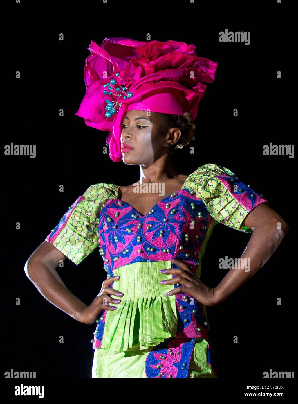 In this Friday, June 21, 2013 photo, a models wears a creation by Senegalese  designer Tapha Fall of Bara Couture, during a runway show in a dusty  marketplace in the working class